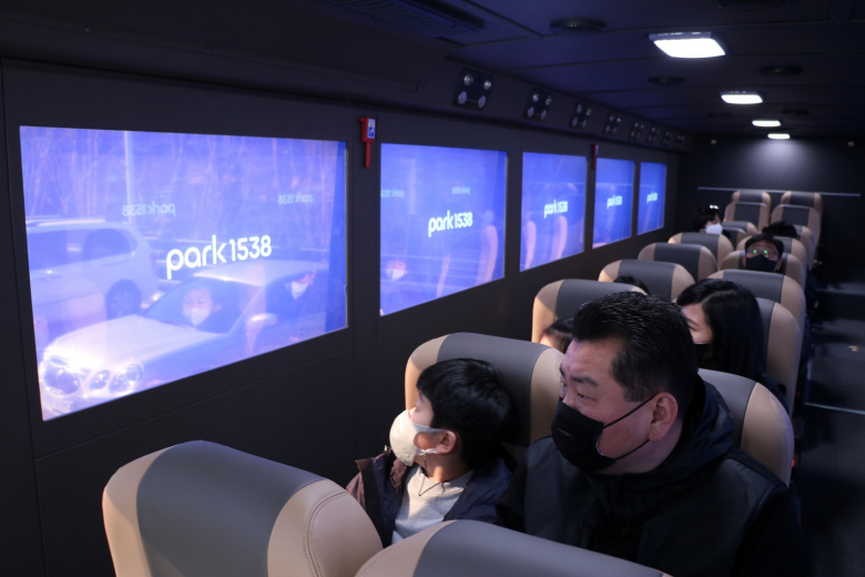 포항제철소 관람객들이 미디어버스에 탑승하여 투명 OLED 화면을 보고 있는 모습