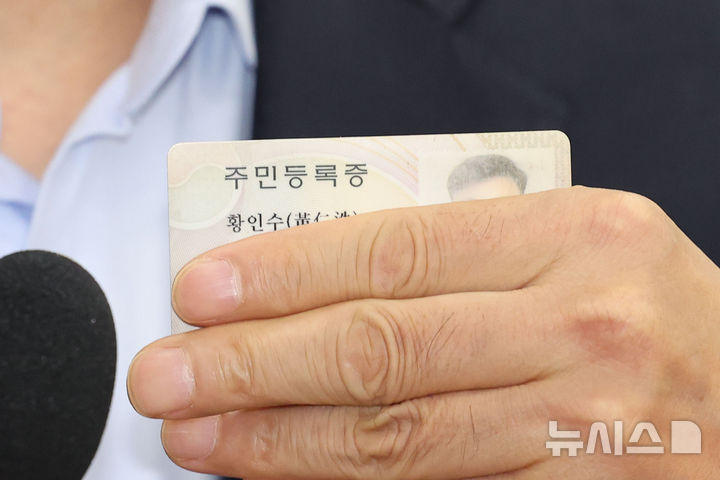 얼굴 공개 대신 주민등록증 든 국정원 출신 국장 <br>황인수 진실화해를위한과거사정리위원회 조사 1국장이  10일 오전 서울 여의도 국회에서 열린 행정안전위원회 국정감사에서 신정훈 행안위원장의 얼굴 공개 요구를 거부하며 주민등록증을 들어보이고 있다. 이날 신 위원장은 황인수 조사1국장을 향해 마스크를 벗으라고 명령했으나 황 국장이 이를 끝내 거부해 황 국장과 김 위원장 모두 퇴장조치 했다. 뉴시스