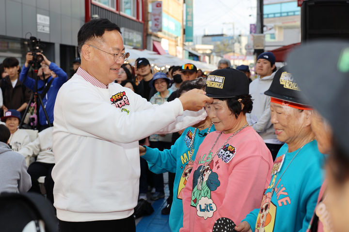김재욱 칠곡군수가 수니와칠공주 할머니들에게 모자를 씌워주고 있다.