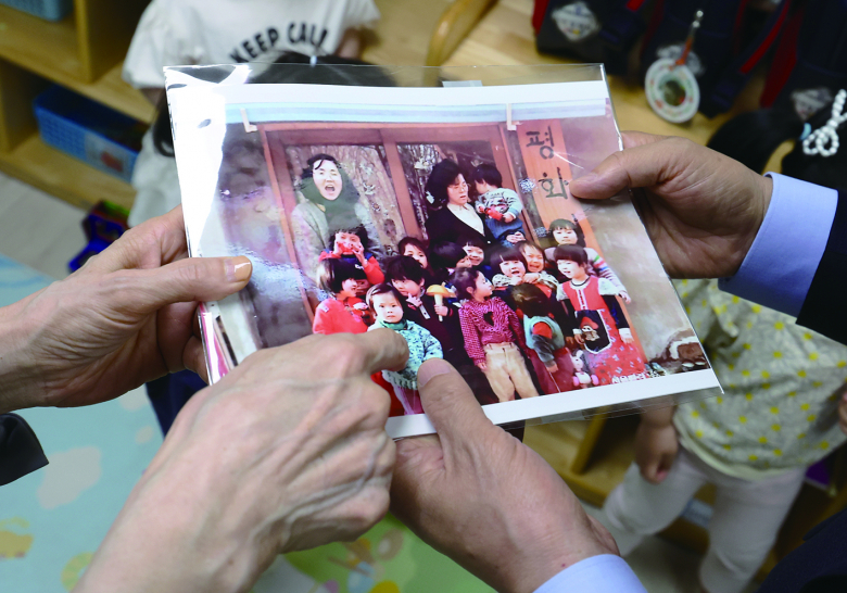 딸 어린시절 사진 보는 김문수 부부<br>김문수 국민의힘 대선 후보와 설난영 여사가 22일 경기 광명시의 한 어린이집에서 아이들을 만나던 중 딸 동주 씨의 어린시절 사진을 보고 있다. 뉴시스