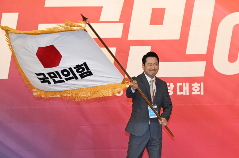 당기 흔드는 장동혁 “나를 따르라”<br>장동혁 신임 국민의힘 대표가 26일 서울 여의도 국회도서관에서 열린 국민의힘 제6차 전당대회 결선에서 선출된 뒤 당기를 흔들고 있다. 뉴시스