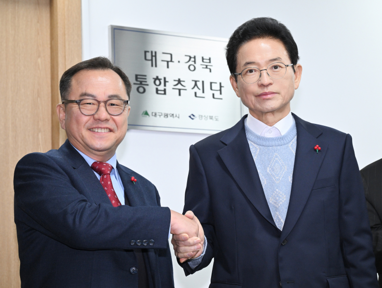 홍성주 대구시 경제부시장(왼쪽)과 이철우 경북도지사가 26일 경북도청에서 ‘대구·경북 통합추진단’ 현판식을 갖고 기념촬영을 하고 있다. <경북도 제공>