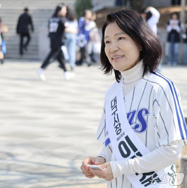 '대구시장 예비후보 이진숙'이라는 어깨띠를 한 이진숙 전 방송통신위원장이 지난 28일 삼성라이온즈-롯데자이언츠와의 프로야구 대구 홈 개막전이 열린 대구라이온즈파크를 찾아 시민들에게 명함을 돌리고 함께 사진을 찍는 등 이름 알리기에 열중했다. 뉴스1