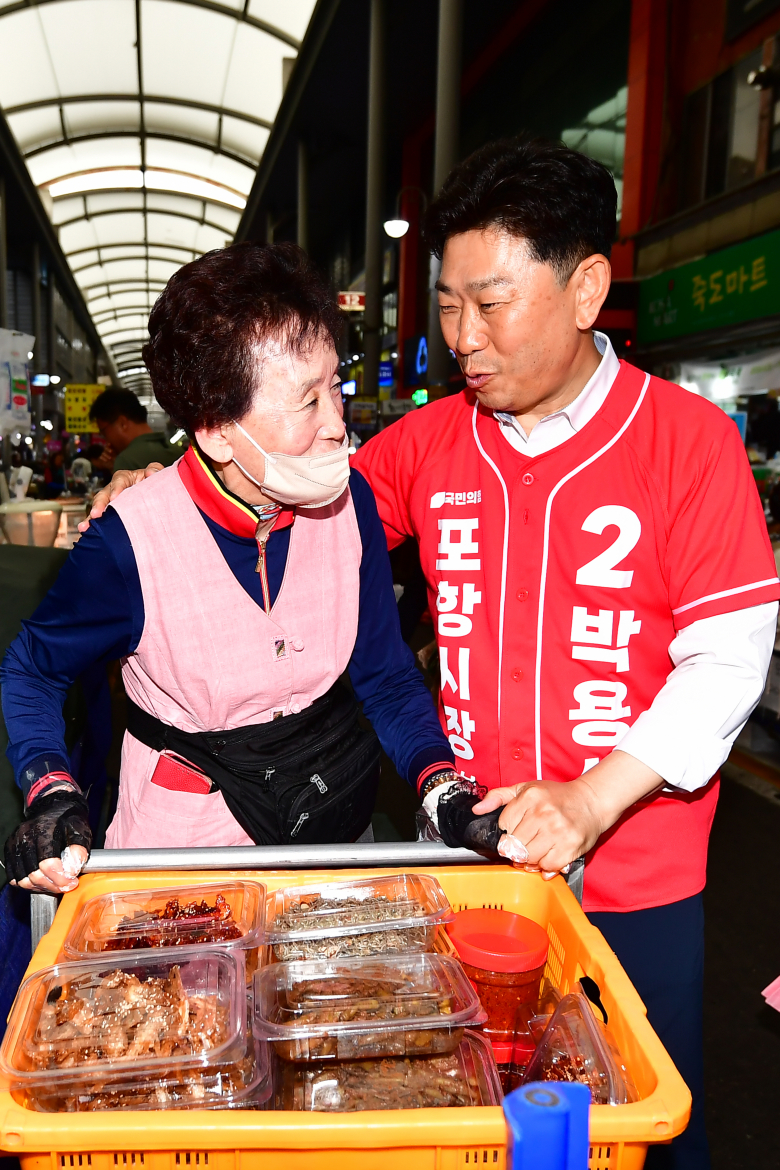박용선 국민의힘 포항시장 후보가 21일 경북 포항 죽도시장에서 상인과 대화하고 있다. 뉴스1