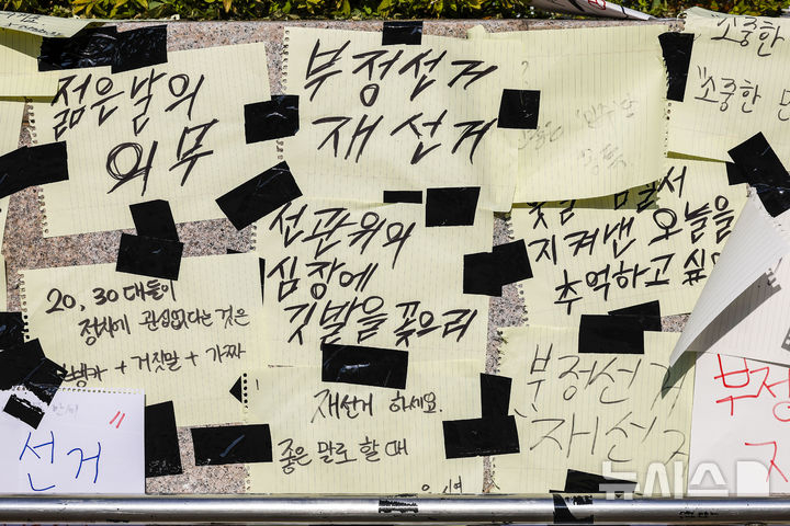 제9회 전국동시지방선거 투표용지 부족 사태에 항의하며 개표소 봉쇄 시위가 이어지고 있는 가운데 9일 서울 올림픽공원 핸드볼경기장에 설치된 개표소 앞에 재선거 촉구 피켓이 붙어 있다. 뉴시스