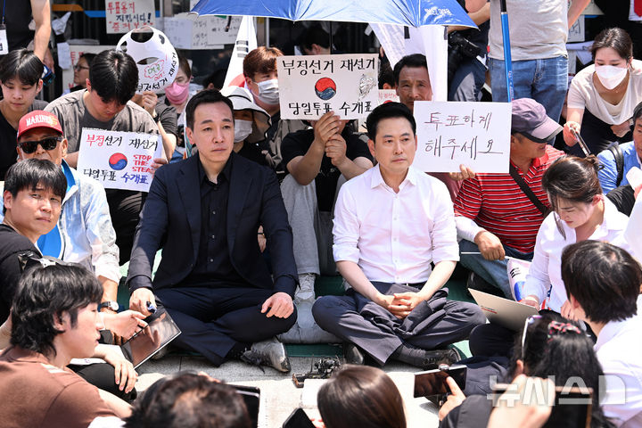 장동혁 국민의힘 대표가 16일 6·3 지방선거 투표용지 부족 사태를 규탄하는 개표소 봉쇄 시위가 이어지고 있는 서울 올림픽공원 핸드볼경기장 앞을 찾아 자리를 깔고 앉아 있다. 뉴시스