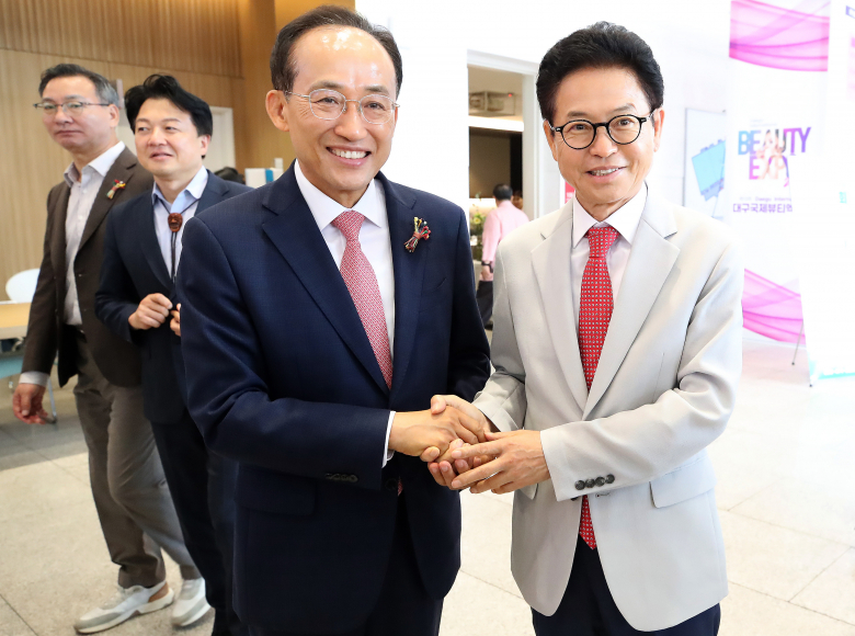 이철우 경북도지사(오른쪽)와 추경호 대구시장 당선인이 11일 오후 대구 북구 엑스코(EXCO)에서 열린 '2026 대한민국불교문화엑스포' 행사장에서 만나 손을 잡으며 인사 나누고 있다. 뉴스1