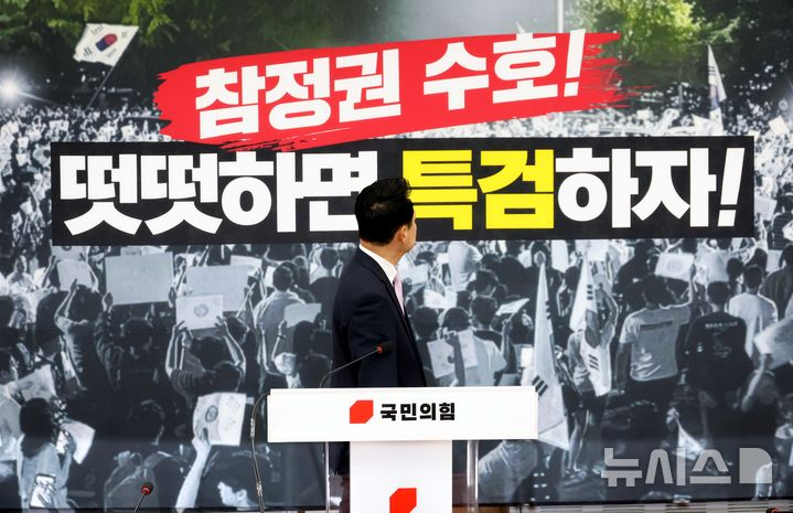 장동혁 국민의힘 대표가 24일 오후 서울 여의도 국회에서 열린 당 현안 관련 기자회견 전 '참정권 수호! 떳떳하면 특검하자' 백드롭의 문구를 확인하고 있다. 뉴시스