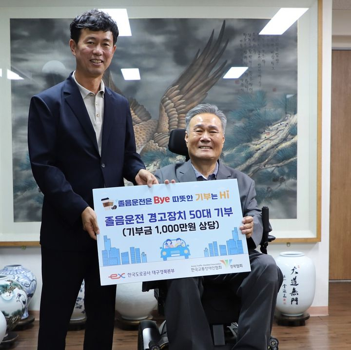 유호식((왼쪽) 한국도로공사 대구경북본부장이 김락환 한국교통장애인협회장에게 졸음운전 경고장치를 전달하고 있다. 뉴시스